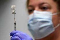 FILE - In this March 2, 2021, file photo, pharmacy technician Hollie Maloney loads a syringe wi ...