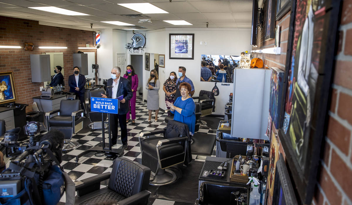 Gov. Steve Sisolak, center, speaks inside the new space at the Eastside Cutters Barbershop duri ...