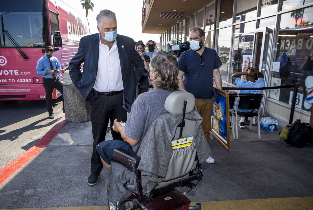 Gov. Steve Sisolak, left, talks with passer-by Todd Schwarting following a tour at the Eastside ...