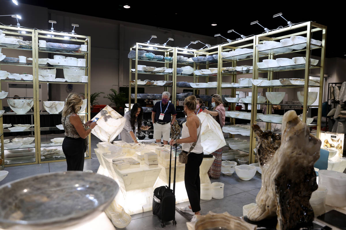 Conventioneers browse the Pierre Verona luxury stone home accents and furniture booth, during t ...