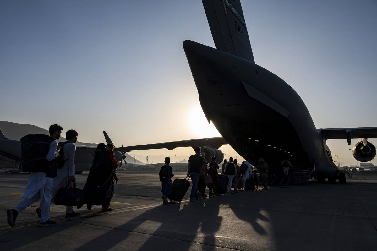 In this image provided by the U.S. Air Force, U.S. Air Force Airmen guides evacuees aboard a U. ...