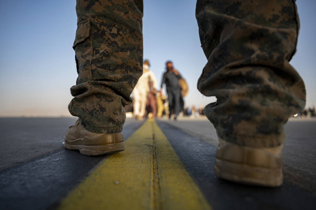 In this image provided by the U.S. Air Force, a U.S. Marine provides security for evacuees boar ...