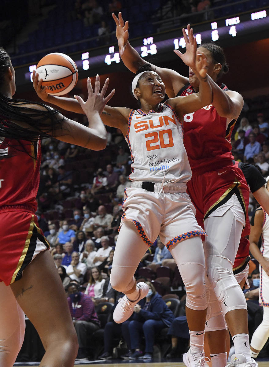 Connecticut Sun's Briann January (20) up for a shot between Las Vegas Aces' Liz Cambage (8) and ...