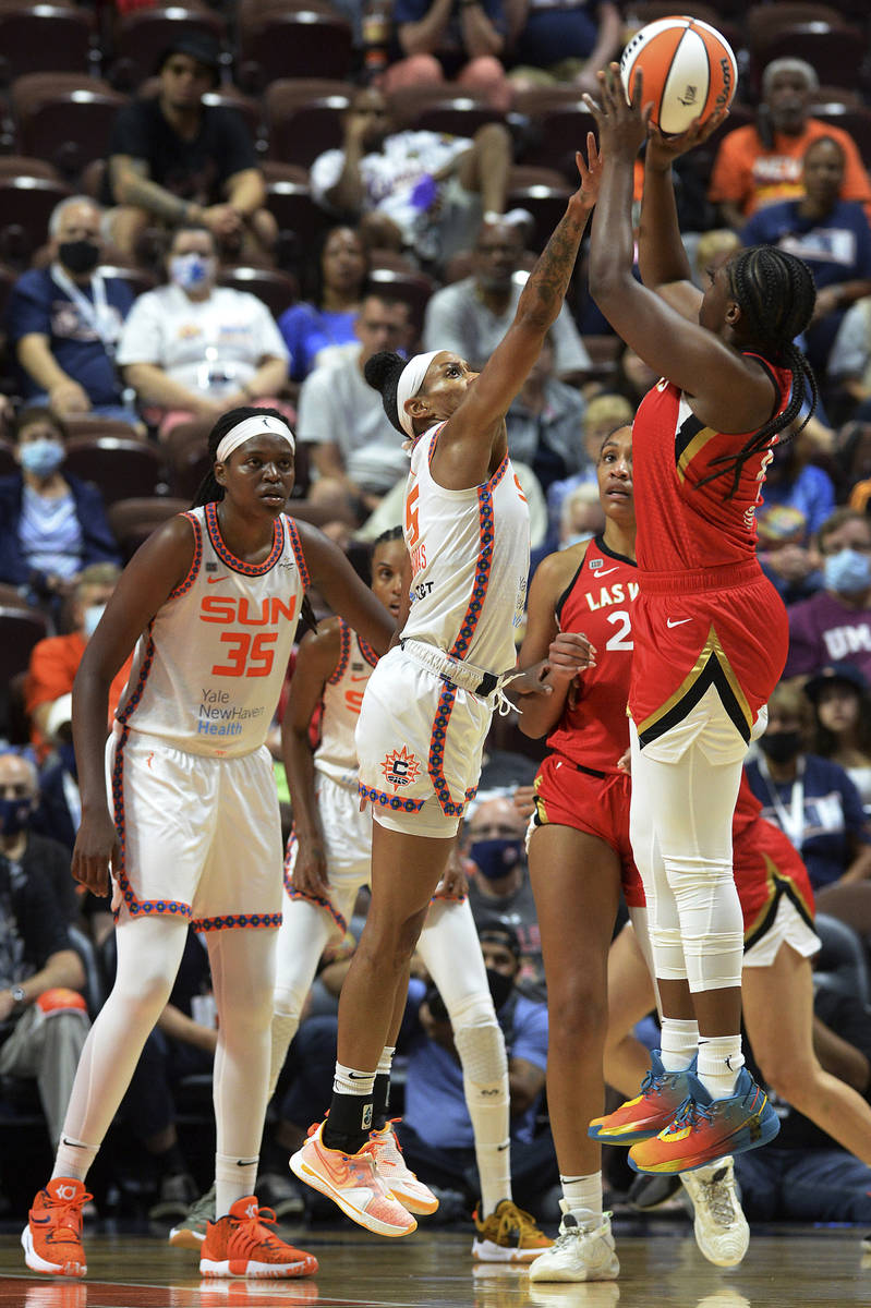 Las Vegas Aces' Chelsea Gray (12) goes up for a shot against Connecticut Sun's Jasmine Thomas ( ...