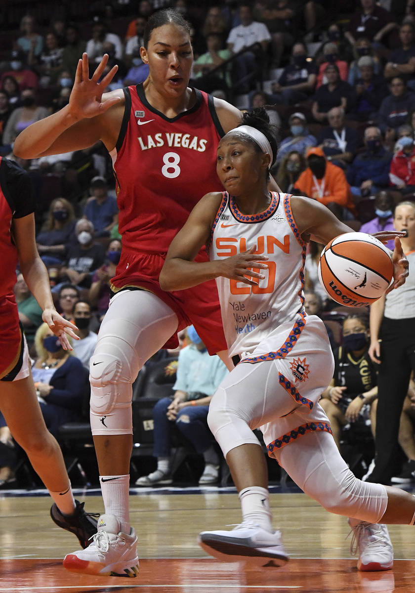 Connecticut Sun's Briann January (20) drives to the basket against Las Vegas Aces' Liz Cambage ...