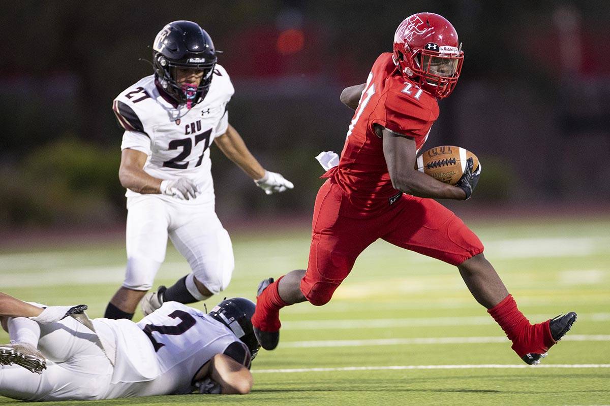 Arbor Views (27) runs the ball past Faith Lutheran's Jack Gentile (2) during the first quarter ...