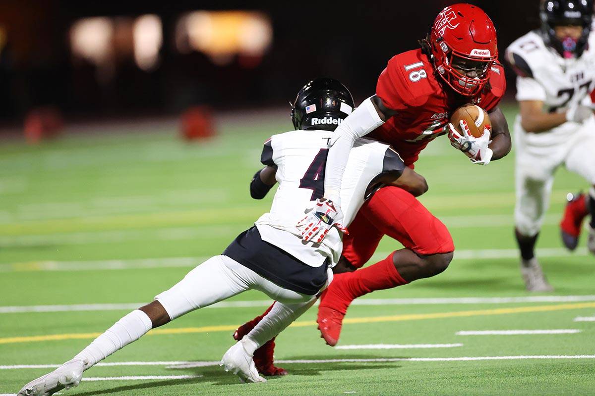 Arbor View's David Washington (18) is tackled by Faith Lutheran's Damien Virgil (4) after a gai ...