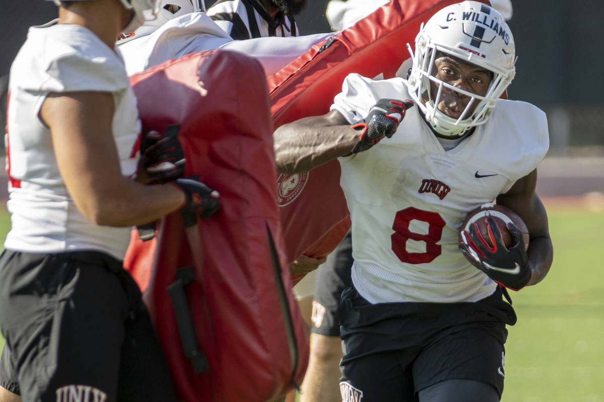 UNLV running back Charles Williams (8) hits a pad on a drill during football team practice at R ...