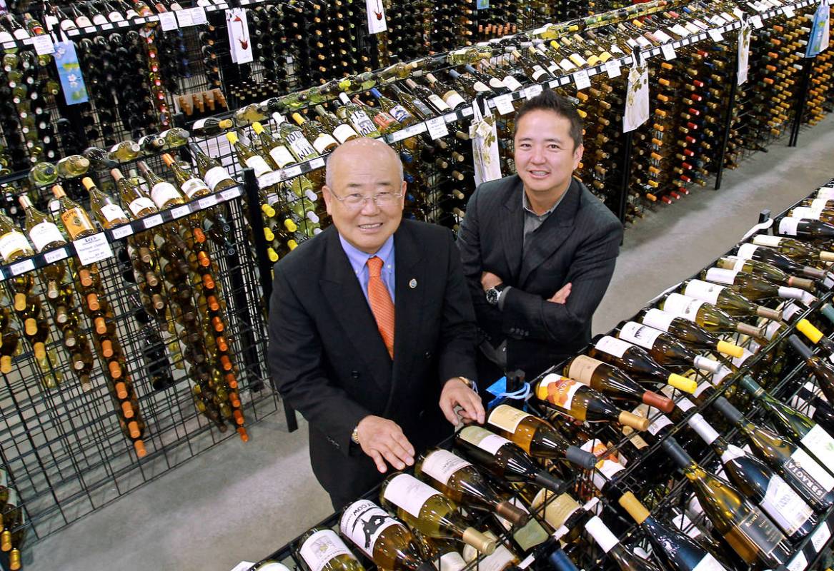 Hae Un Lee, founder of Lee's Discount Liquor, left, stands with his son, Kenny Lee, in their st ...