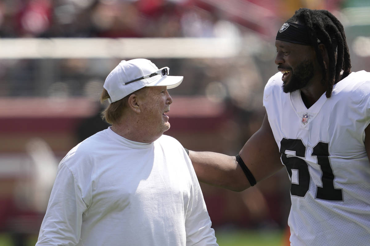 Las Vegas Raiders owner Mark Davis, left, talks with Gerald McCoy before an NFL preseason footb ...