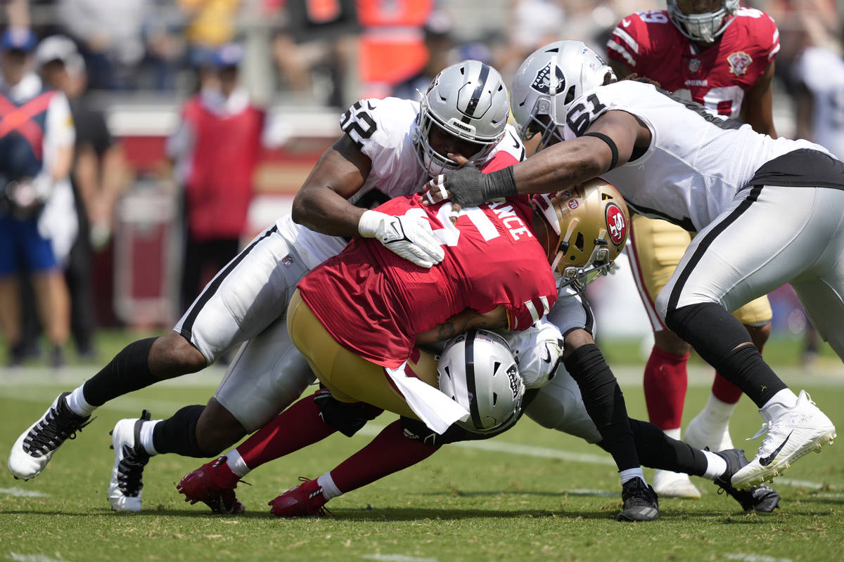 San Francisco 49ers quarterback Trey Lance (5) is tackled by Las Vegas Raiders defensive end Ge ...