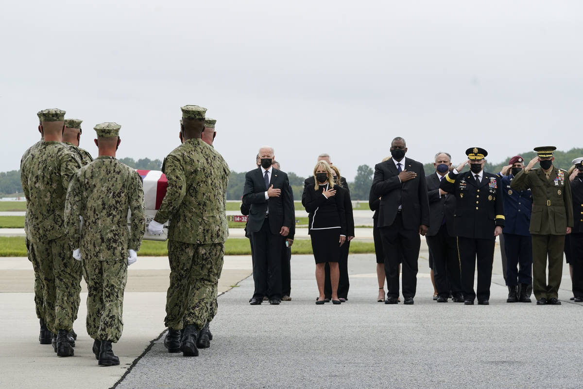 President Joe Biden watches as a Navy carry team moves a transfer case containing the remains o ...