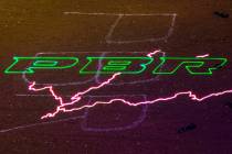A PBR logo with lightning projected on the dirt ring during the last day of the PBR World Final ...