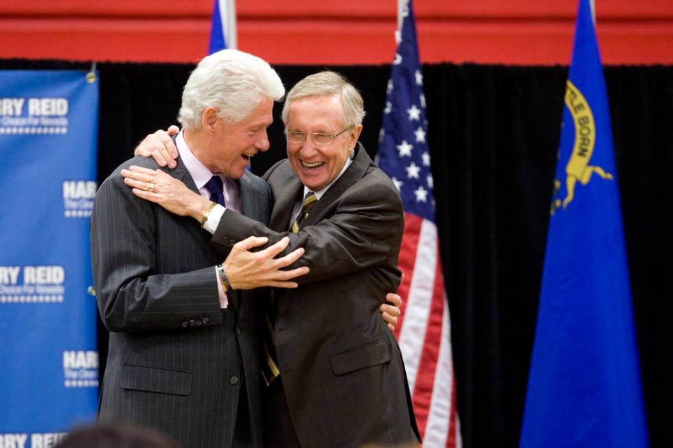 Former President Bill Clinton, left, shares a laugh and a hug with U.S. Senator Harry Reid, D-N ...