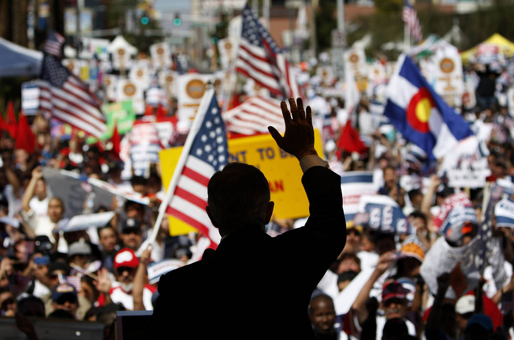 U.S. Senator Harry Reid, D-Nev., waves to a crowd of protesters during an immigration reform ra ...