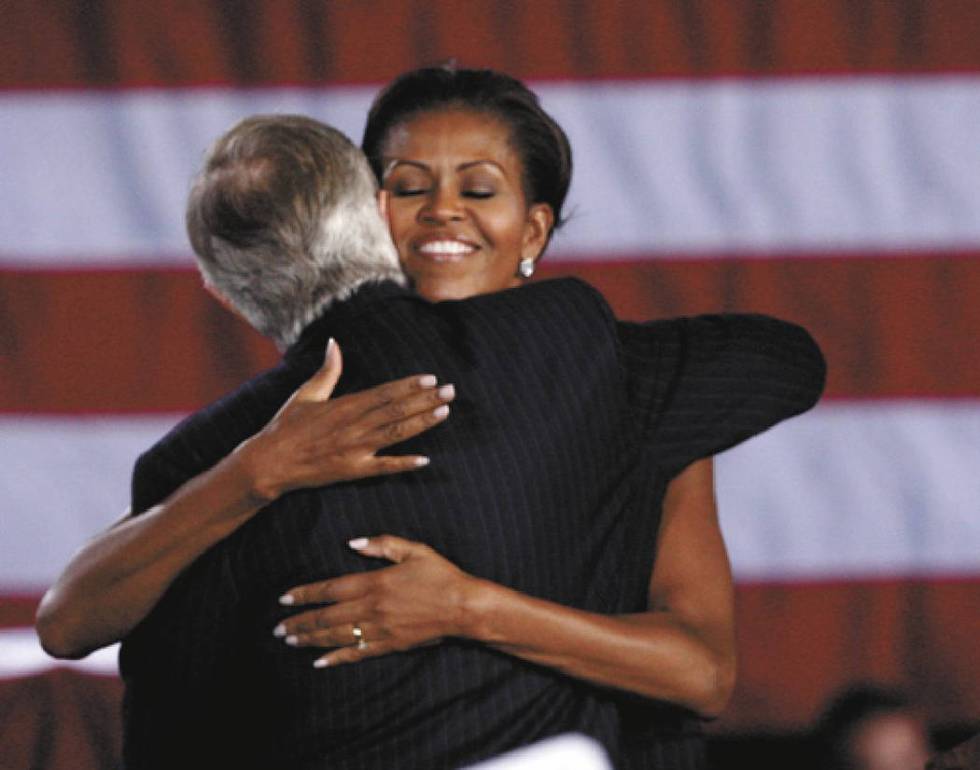 First lady Michelle Obama hugs U.S. Senator Harry Reid, D-Nev., at Canyon Springs High School i ...