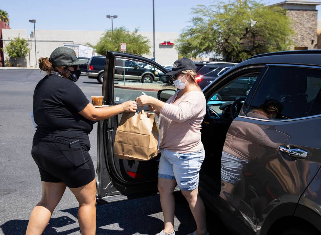 Michelle English, right, a delivery driver for Loco Co-Op, delivers food to ShowGrow Dispensary ...