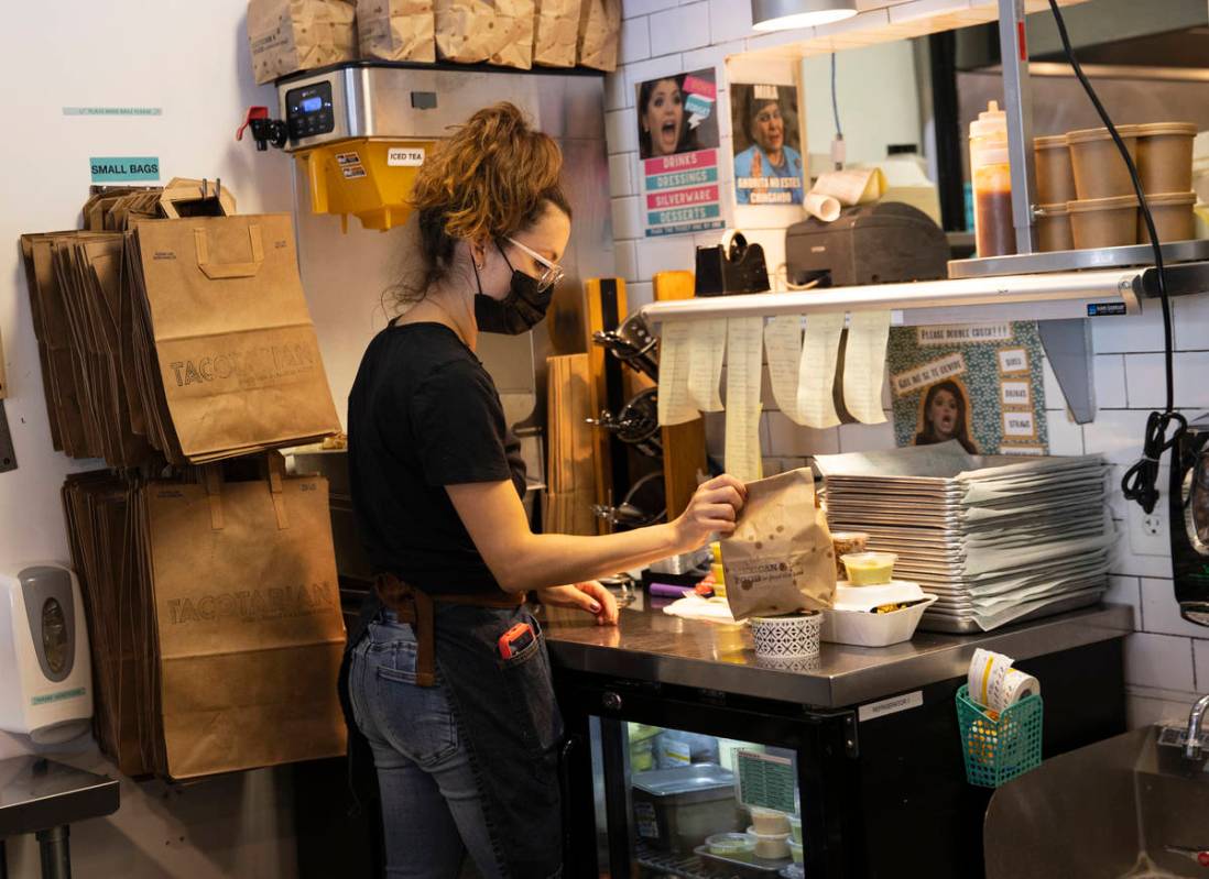 Sandra Ruiz, Tacotarian manager, check out customers orders as she prepares them to be delivere ...