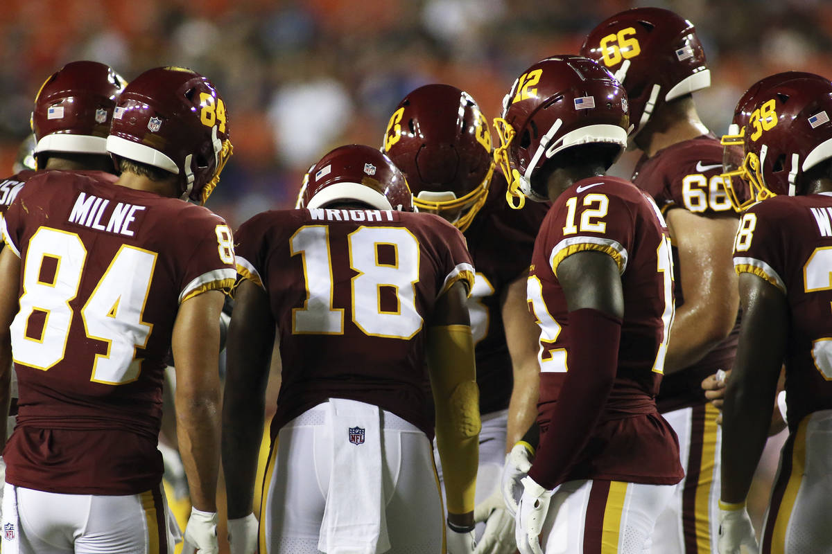 Washington Football Team players huddle up during an NFL preseason football game against the Ba ...