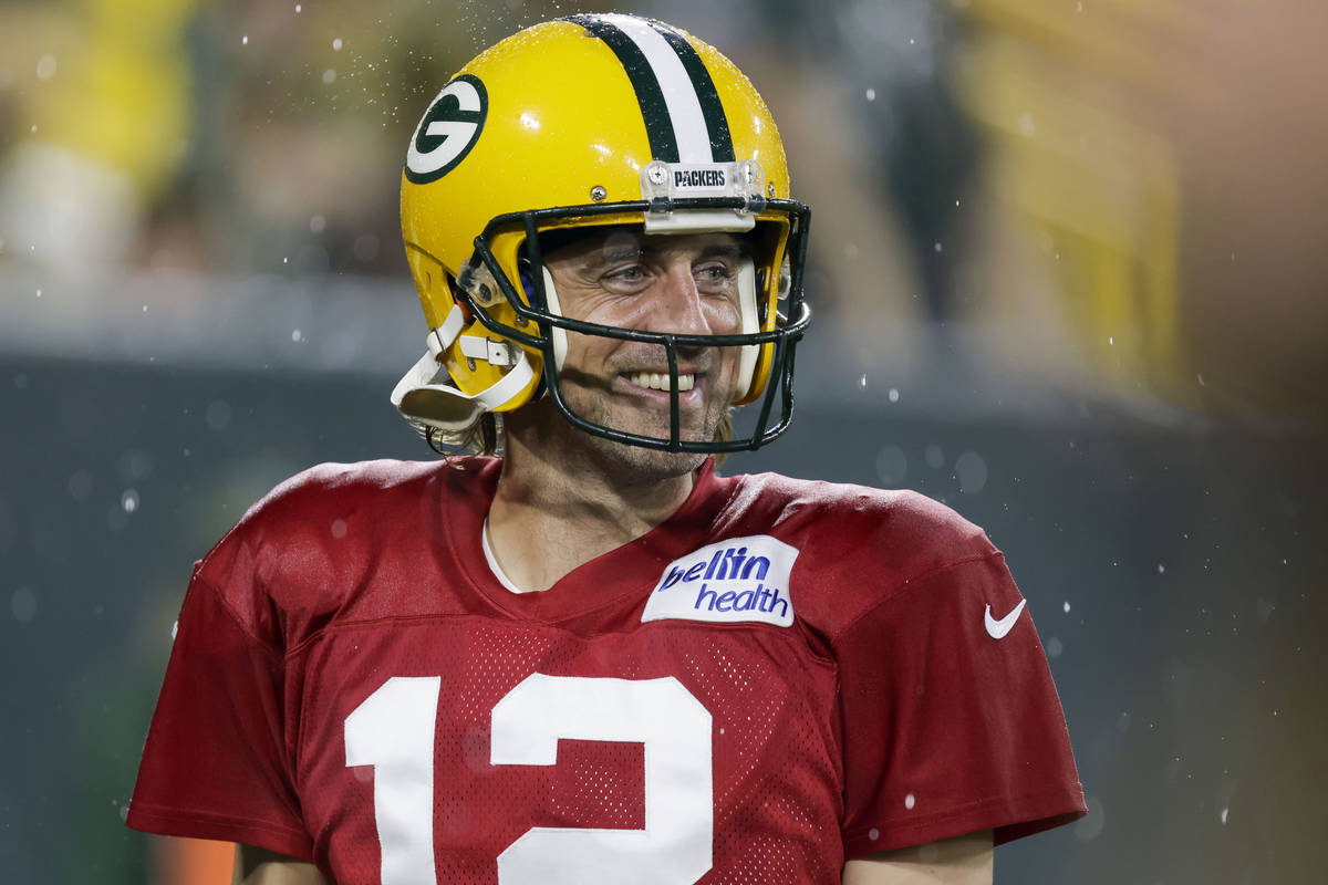 Green Bay Packers quarterback Aaron Rodgers smiles as he walks off the field during NFL footbal ...