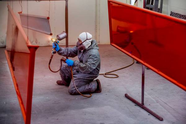 Jomar Reyes sprays red paint on the panels of Frank Pizarro's 1991 Pierce firetruck at Firetruc ...