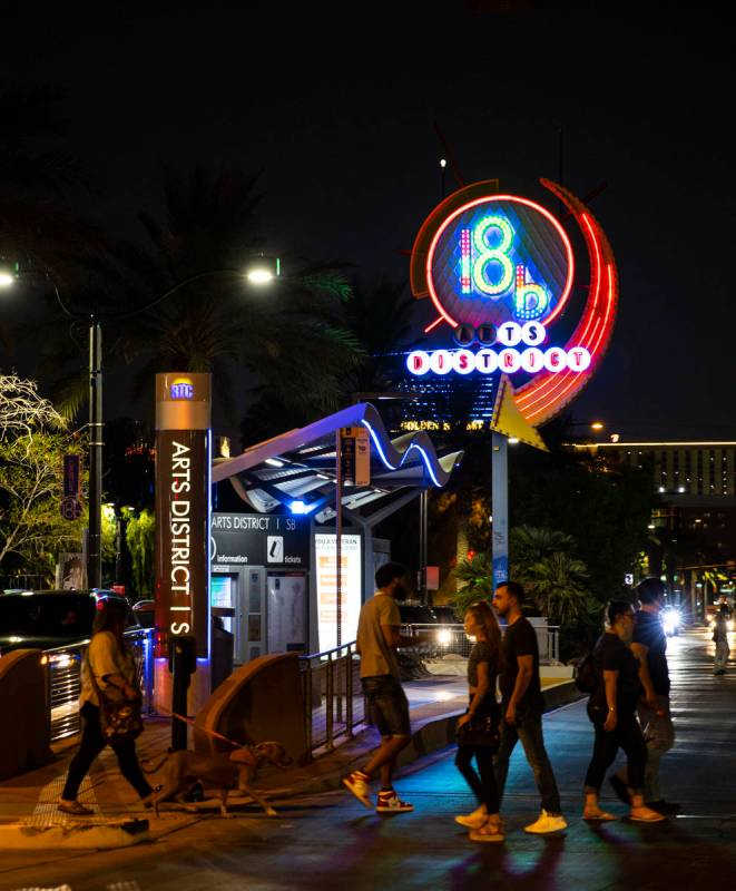 People cross the street near the 18B Arts District neon sign during First Friday in downtown La ...