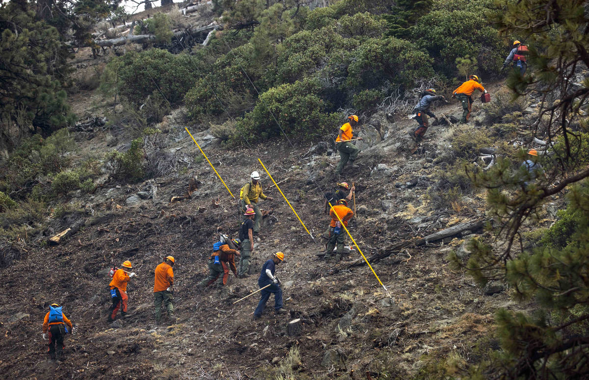 A fire crew hikes up a ridge along SR 207 from the Caldor Fire on Wednesday, Sept. 1, 2021, wes ...