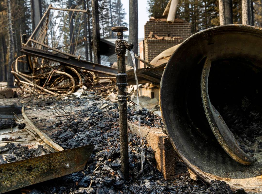 Water runs from a faucet at a home destroyed by the Caldor Fire in the Phillips Park neighborho ...