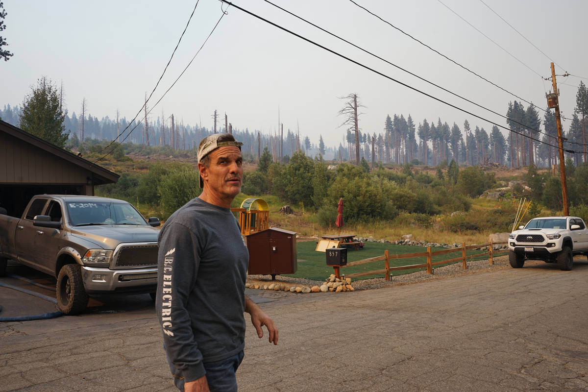 John Rhodes stands Tuesday, Aug. 31, 2021, in his Meyers, Calif., neighborhood in front of char ...