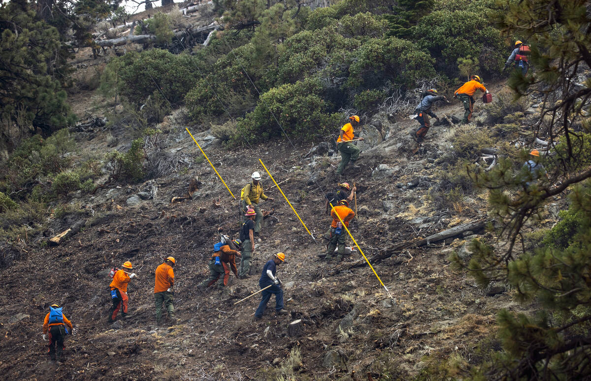 A fire crew hikes up a ridge along SR 207 from the Caldor Fire on Wednesday, Sept. 1, 2021, wes ...