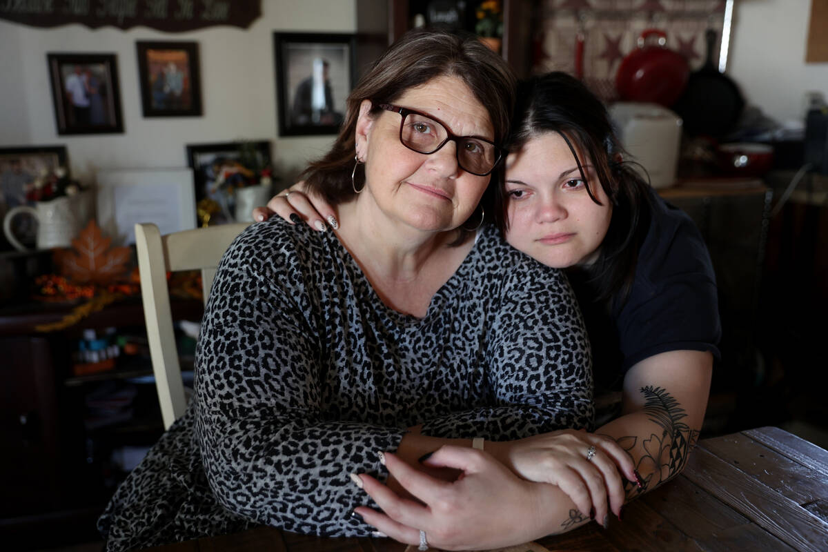 Vena Foster, whose sister died of COVID-19 shortly after becoming a mother, gets a hug from her ...