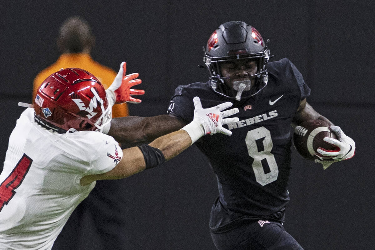 UNLV Rebels running back Charles Williams (8) fends off a tackle attempt by Eastern Washington ...