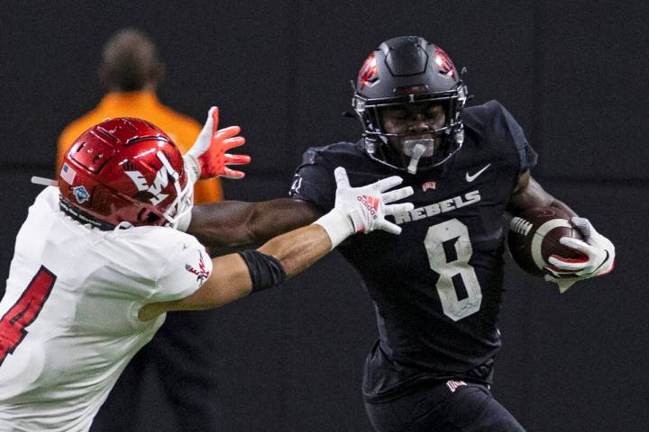 UNLV Rebels running back Charles Williams (8) fends off a tackle attempt by Eastern Washington ...