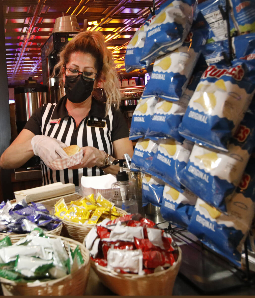 Snack Bar Attendant Loretta Maletto makes a hotdog for a customer at El Cortez in Las Vegas, Sa ...