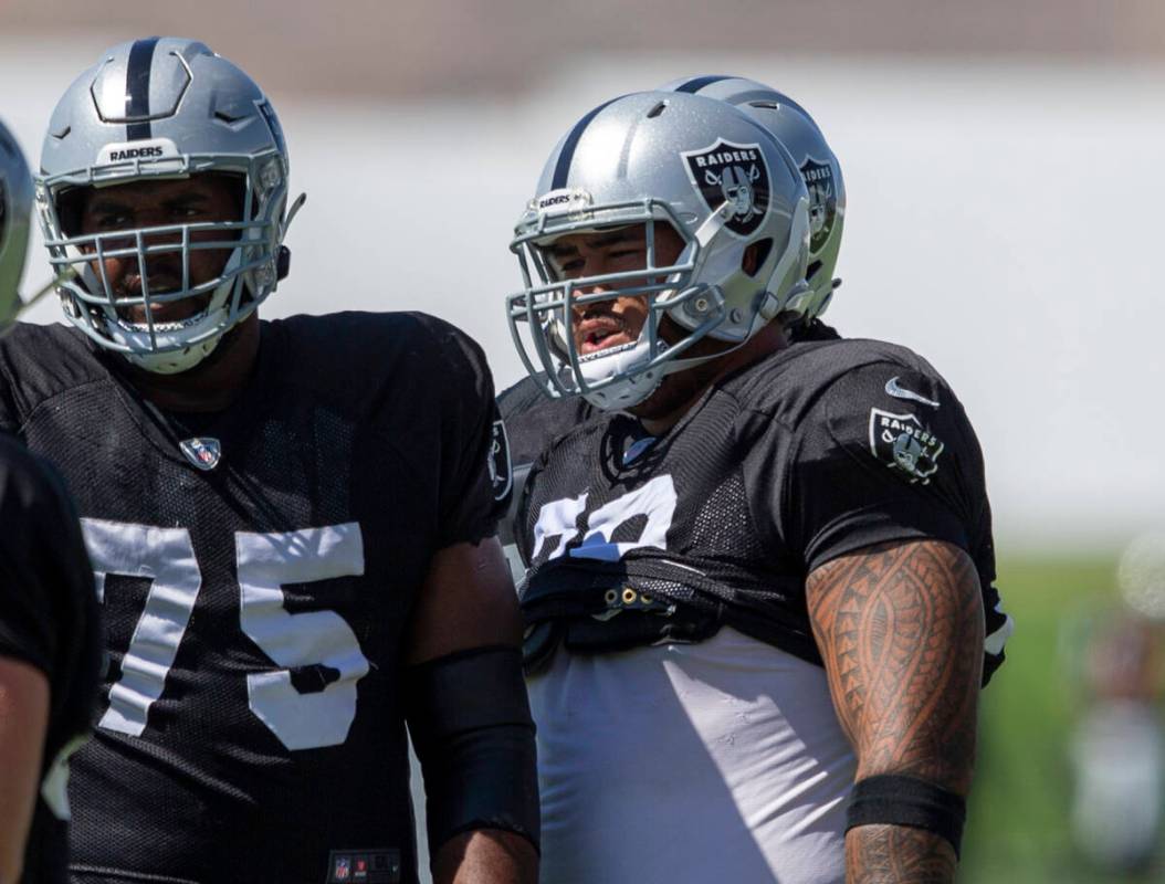 Raiders offensive lineman Jeremiah Poutasi (79) looks on with offensive tackle Brandon Parker ( ...