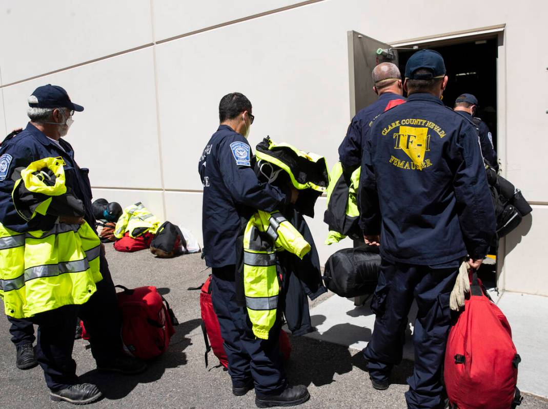 Members of the Nevada Task Force 1, including Dennis West, left, lined up, to return their equi ...