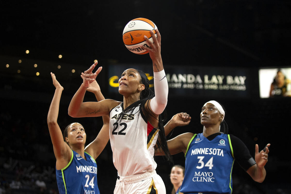 Las Vegas Aces forward A'ja Wilson (22) goes for a layup flanked by Minnesota Lynx forward Naph ...