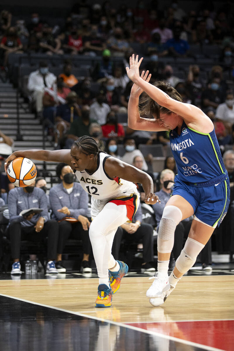 Las Vegas Aces guard Chelsea Gray (12) dribbles toward the hoop while Minnesota Lynx forward Br ...