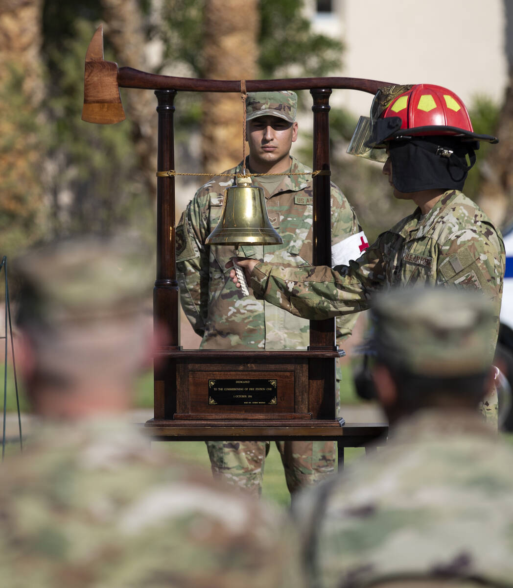 Military members ring a bell dedicated to Fire Station One during the Nellis Fire and Emergency ...
