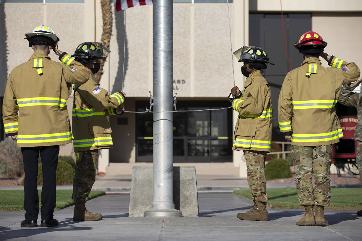 Firefighters lower the American Flag to half-staff during the Nellis Fire and Emergency Service ...