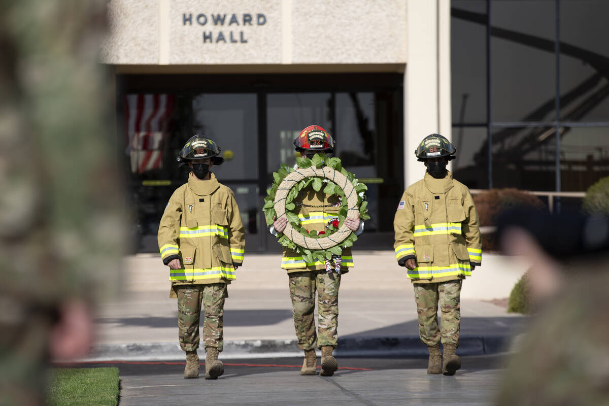 Firefighters participate in a wreath-hanging ceremony at the Nellis Fire and Emergency Services ...