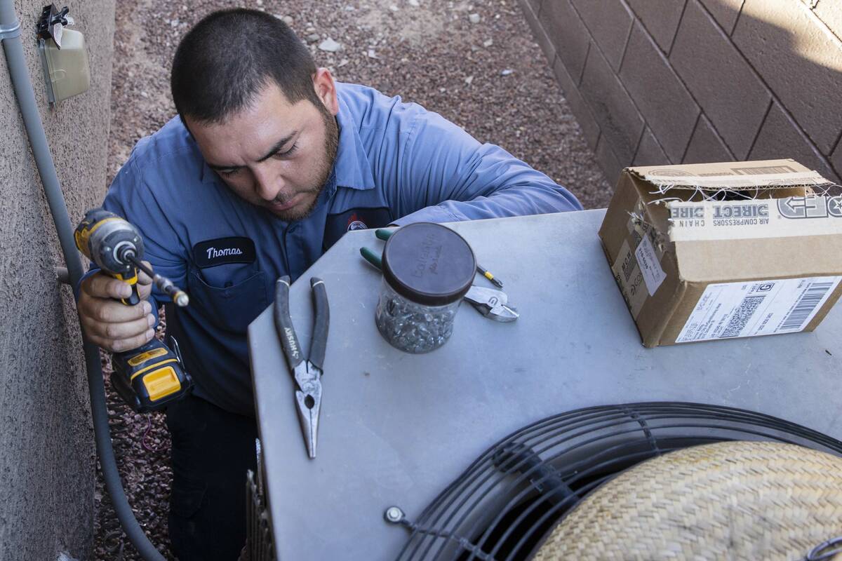 Windy City Air's technician Thomas Padron repairs an air conditioner at Vulcan St, on Friday, S ...