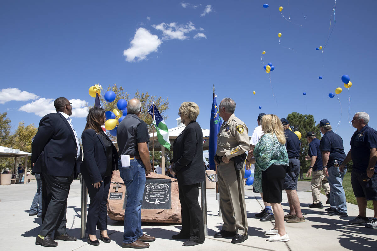 Local government leadership watches as balloons are released in honor of the first responders w ...