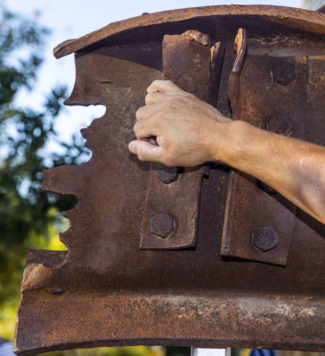 An attendee touches a piece of World Trade Tower steel on display, Saturday, Sept. 11, 2021, at ...