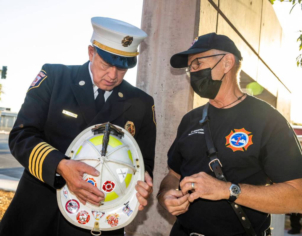 City of Las Vegas Fire Marshal Robert Nolan, left, looks over an old fire helmet from former An ...