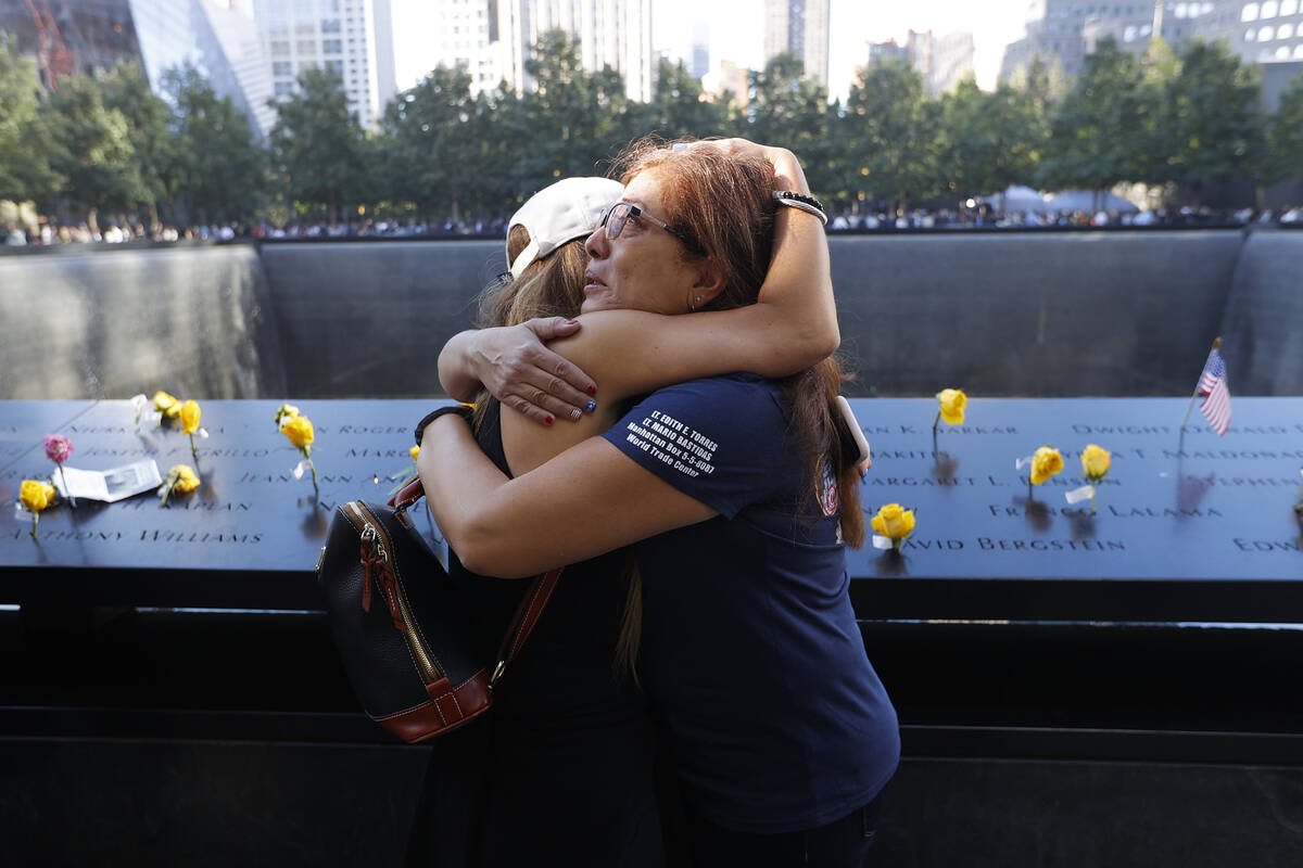Melinda Moran and Haydee Lillo embrace after finding out they lost people who knew each other, ...