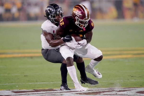 UNLV defensive back Aaron Lewis tackles Arizona State wide receiver Andre Johnson (82) during t ...