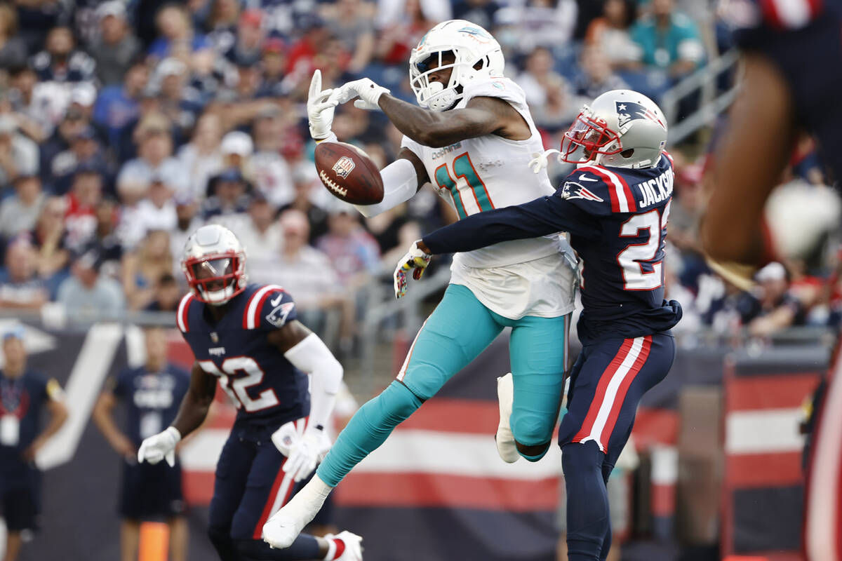 New England Patriots defensive back J.C. Jackson, right, breaks up a pass to Miami Dolphins wid ...