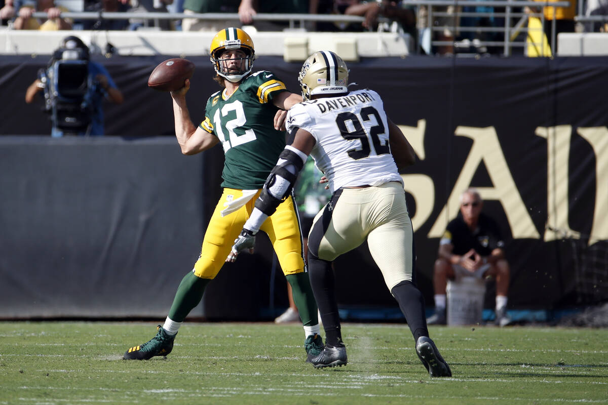Green Bay Packers quarterback Aaron Rodgers (12) throws a pass as he is pressured by New Orlean ...