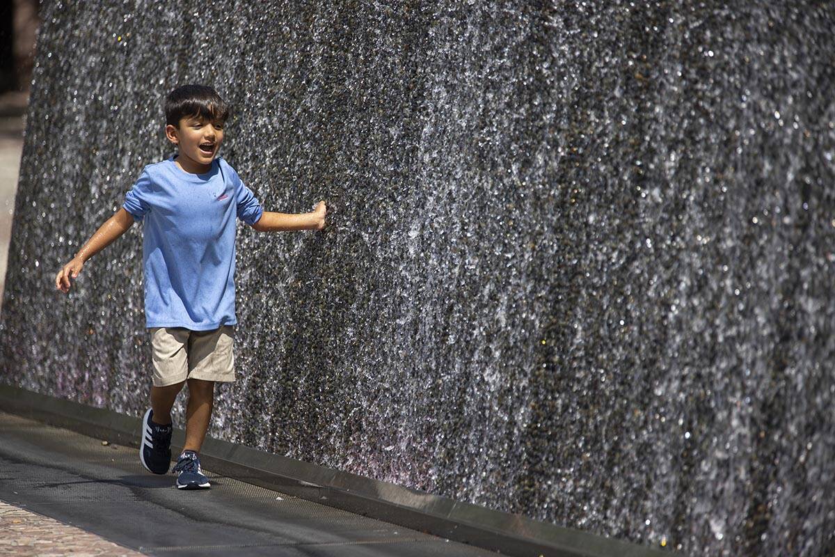 Ian Alaniz, 5, of Dublin, Texas, touches a water feature outside of the New York-New York hotel ...